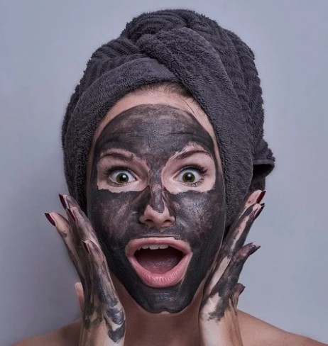 Femeie cu expresieuimita cu masca neagra cosmetica pe chip