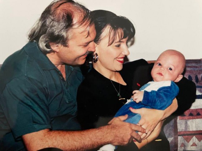 Victor Socaciu si Marina Almasan uitandu-se cu adoratie la fiul lor Victor, bebelus