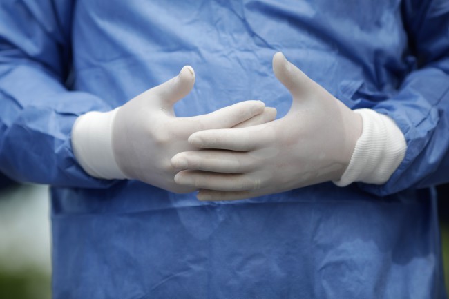 Imagine cu 2 maini de chirurg cu manusi albe medicale