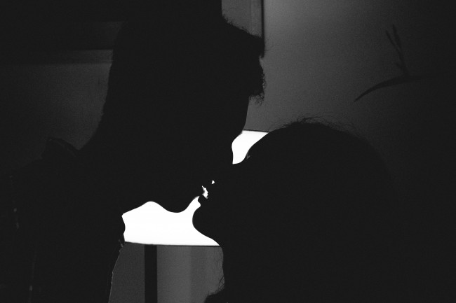 Poza alb  negru cu siluetele unor tineri care se saruta