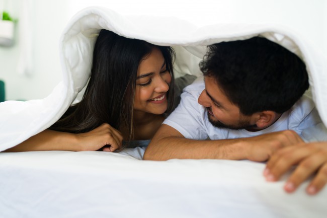 Cuplu frumos care se ascunde sub pături