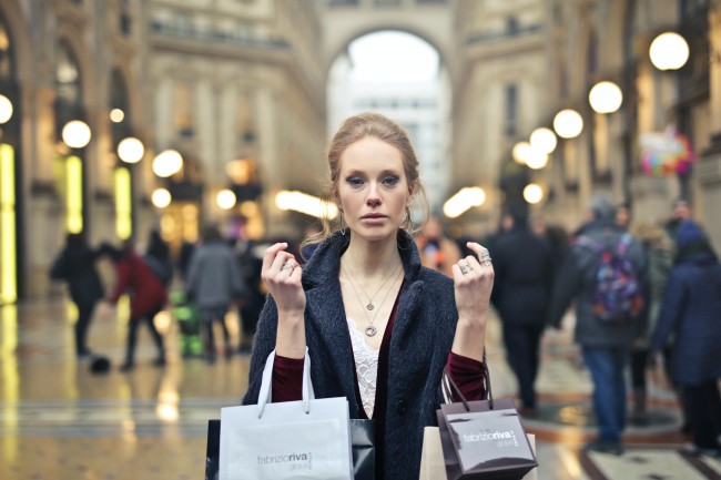Femeie  roscata, eleganta, cu pungute de cumparaturi, in Milano