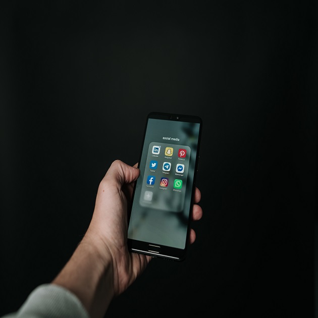 femeie cate tine un telefon in mana si se uita catre el