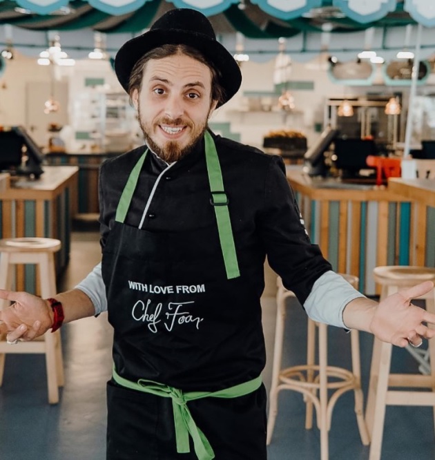 Chef Foa, în bucătărie, purtând un șorț personalizat