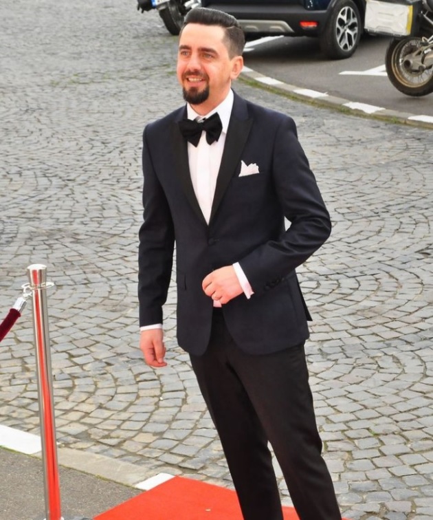 Cosmin Natanticu îmbrăcat la costum pe un covor roșu