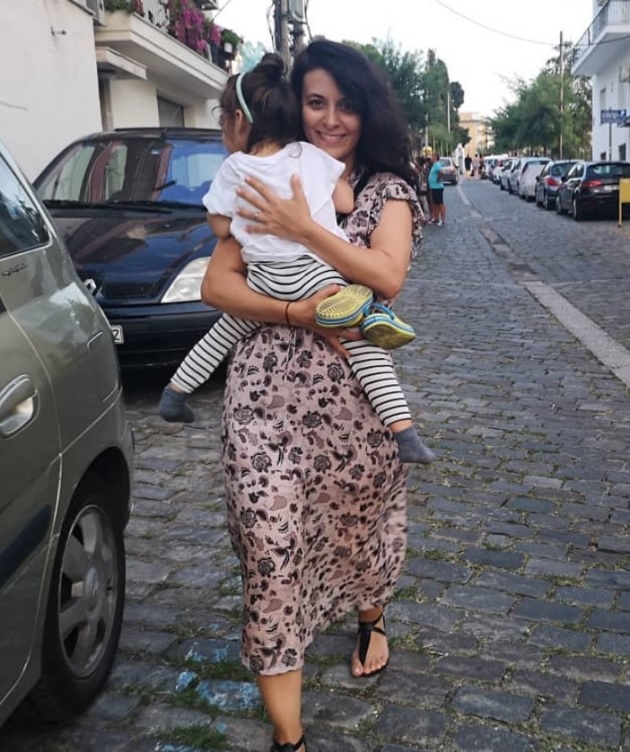 Soția lui Dan Bordeianu, Teodora, care merge pe o stradă pietonată, cu fetița lor în brațe