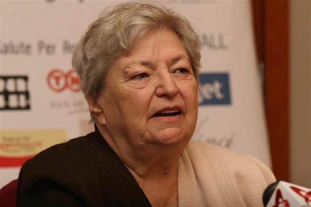 Draga Olteanu Matei în fața unui microfon, dând un interviu