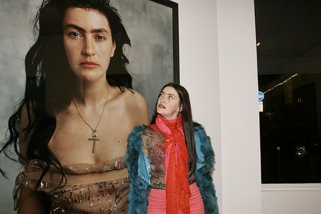 Rona Hartner de tânără privind un tablou mare cu portretul ei