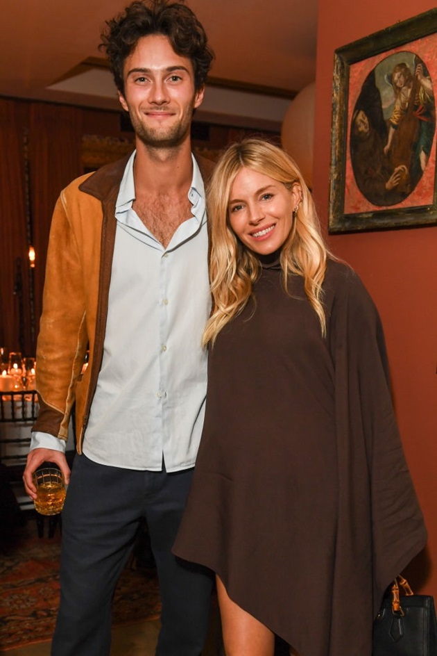 Sienna Miller și Oli Green. Ea ținând geanta în mână și el un pahar de băutura