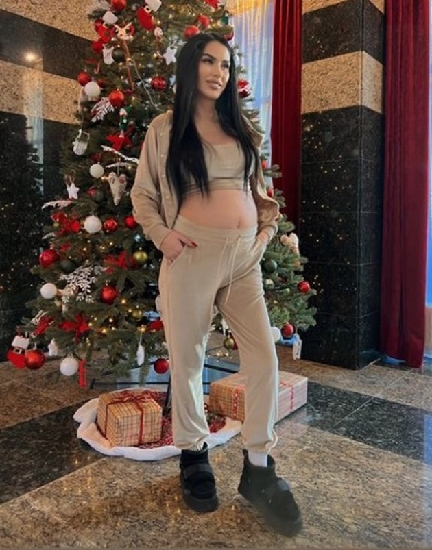 Daniela Crudu cu burtica de gravida la vedere în fața unui brad de crăciun uriaș