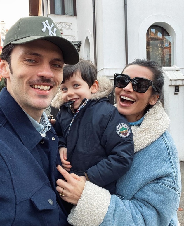 Poză cu Lili Sandu, Silviu Țolu și fiul lor Thomas Jay cu zâmbetul pe buze, îmbrăcați casual