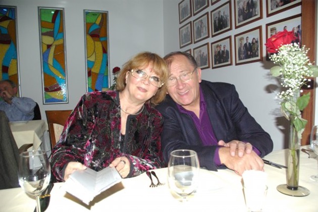 Valeria și Virgil Ogășanu, zâmbind și stând așezați la masă unui restaurant 