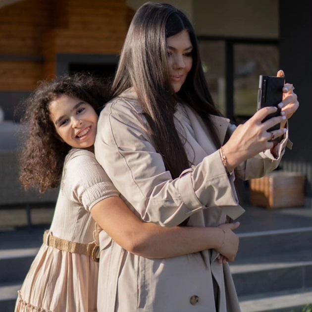 Paula Seling tinând telefonul in mână pentru a face o poză iar fiica ei Elena, îmbrățișând-o din spate cu un zâmbet până la urechi