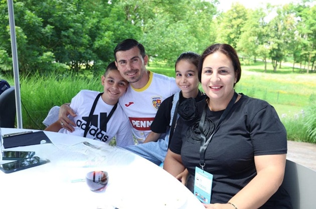 Florin Nita alături de soția sa și cei doi copii ai cuplului, stând la o terasă într-o zonă verde