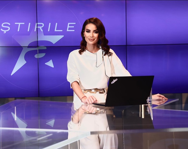 Geanina Ilies la pupitrul stirilor Antena Stars, într-o rochie albă