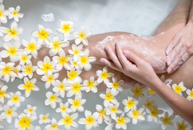 femeie isi face baie in apa cu flori