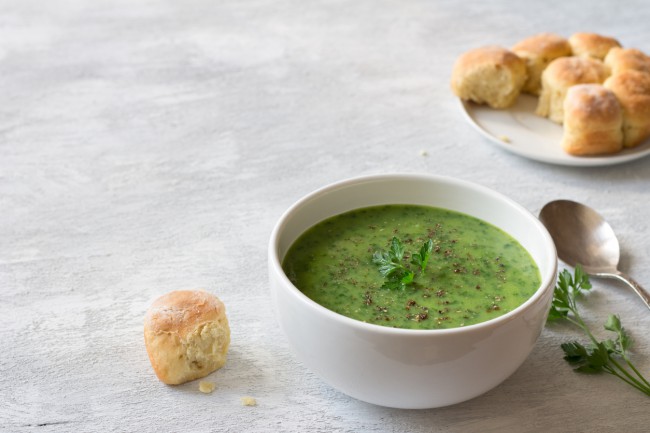 ciorba de spanac in bol alb cu bucata de paine si lingura