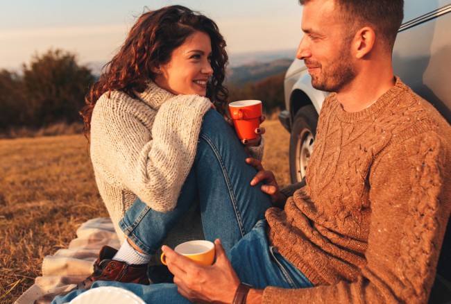 cuplu tanar si fericit la picnic in natura langa masina