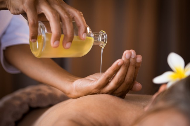 femeie care face masaj cu uleiuri esentiale
