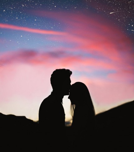 cuplu care se saruta cu fundalul unui cer roz, iubire impartasita