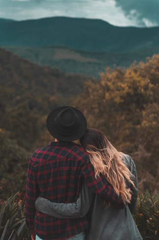 cuplu imbratisat aflat in vacanta la munte care priveste cerul, cuplu hippie si tanar