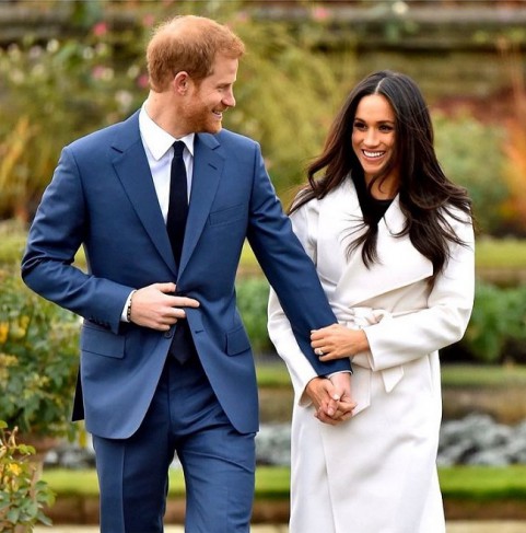 meghan markle imbracata in palton alb alaturi de harry in costum albastru