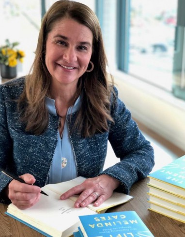 melinda gates intr-un sacou albastru da autografie pe cartea sa