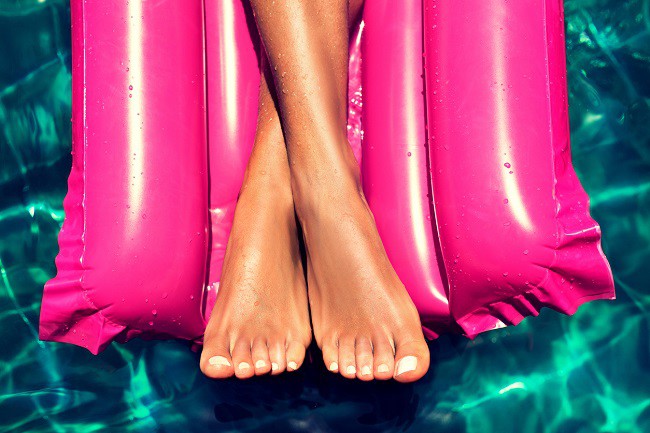 femeie pe saltea pe apa cu unghii colorate