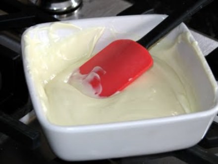 caston cu glazura alba si spatula din silicon alaturi de borcan cu glazura