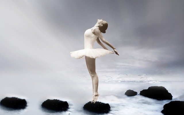 balerina care danseaza pe pietre aflate intr-un rau