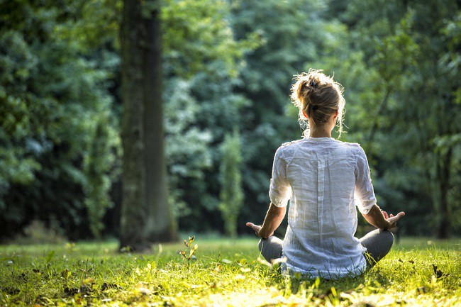 femeie care mediteaza in parc