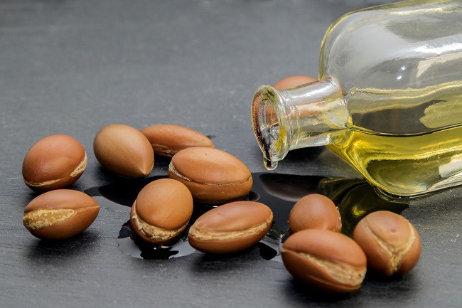 seminte de argan alaturi de sticluta de ulei de argan varsat