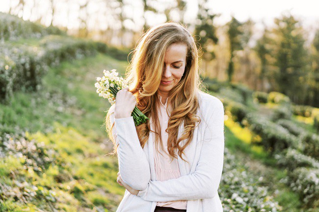 femeie care tine un buchet de flori pe un capm