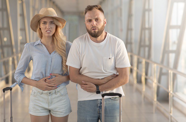 cuplu care sufera de dureri de stomac in aeroport