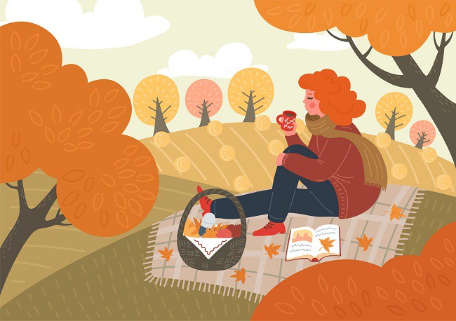 femeie la picnic toamna care citeste si bea cafe