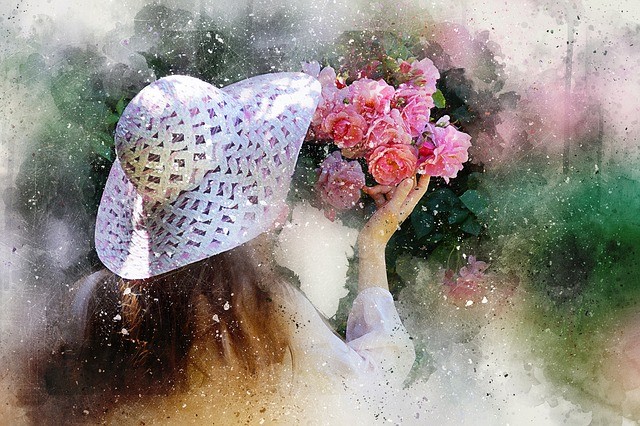 femeie cu palarie alba si vintage care miroase un buchet mare de flori