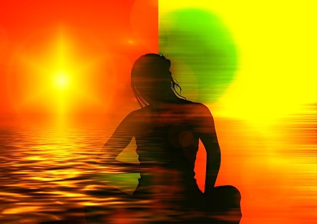 femeie care mediteaza cu apa si un soare stralucitor pe fundal