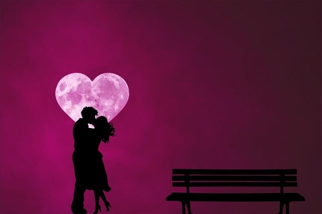 cuplu care se saruta in fata unei luni in forma de inima