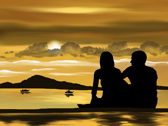 cuplu care se uita la un orizont auriu si la mare