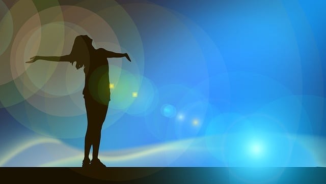 fata fercita care sta cu mainile desfacute si se bucura de lumina soarelui la asfintt