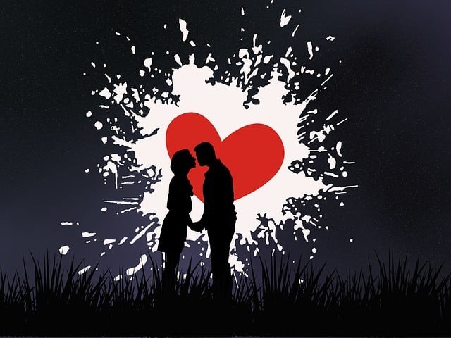 cuplu care se saruta in fata cerului negru pe care e desenata o inima