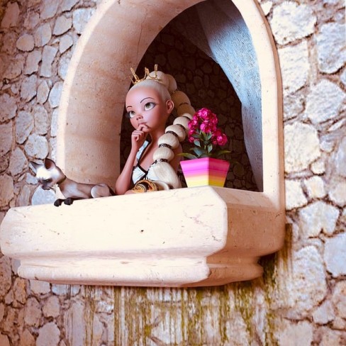 imagine cu Rapunzel care sta la balcon si priveste in zare alaturi de o pisica