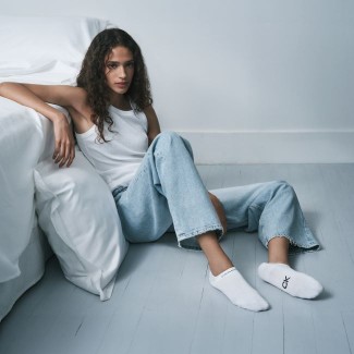 fata imbracata in blugi si maiou alb si sosete calvin klein