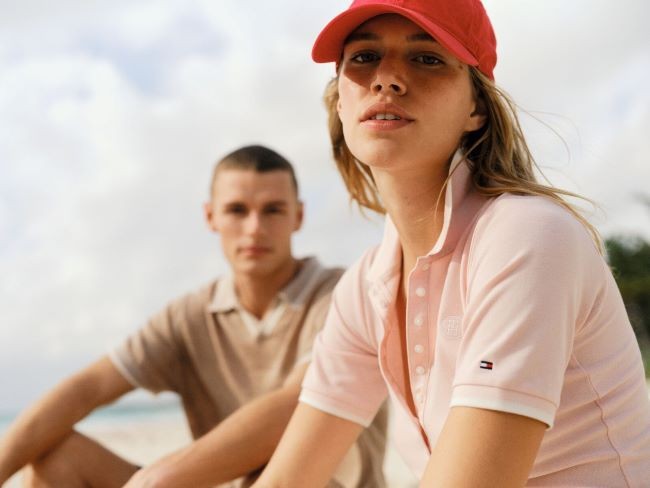 fata in prim plan in tricou polo roz cu un baiat in departare