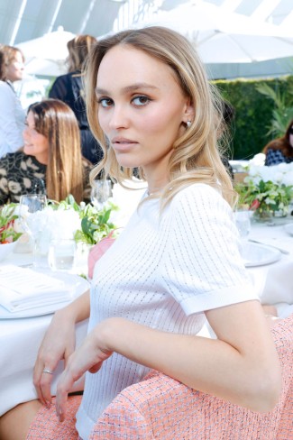 lily rose depp la o masa de gala cu par blond si intoarsa pe jumatate