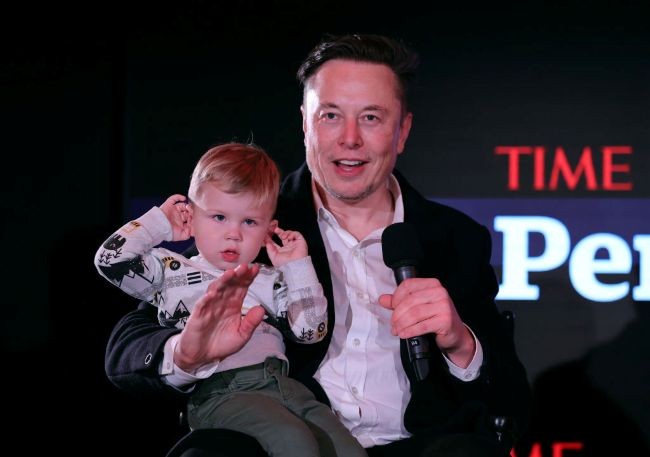elon musk in costum isi tine in brate fiul x la un eveniment