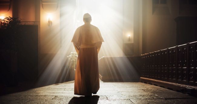 imagine cu un papa care sta cu spatele in lumina revarsata dinspre vitralii