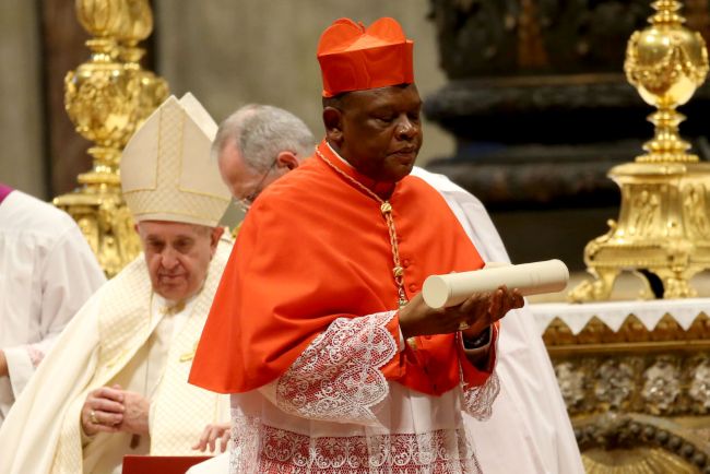 Fridolin Ambongo Besungu in vesmant rosu in timp ce slujeste in biserica