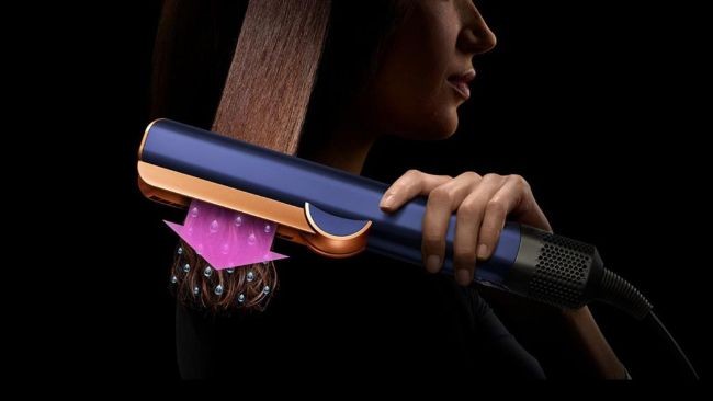 femeie care foloseste aparatul de indreptate Dyson Airstrait™
