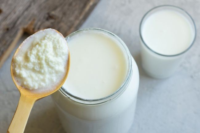 borcan cu kefir si lingura de lemn cu drojdii de kefir